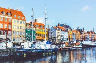 Nyhavn í Kaupmannahöfn. Litrík hús við kanalinn, fyrir framan þau bátar og seglskútur.