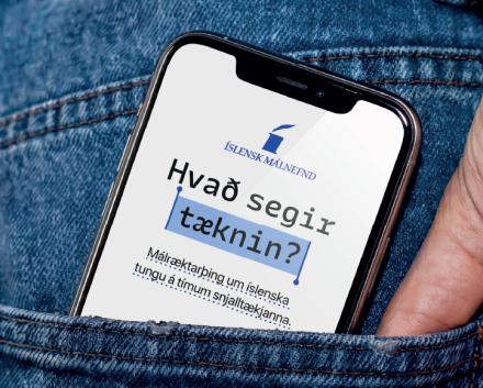 Sími stendur upp úr gallabuxnavasa. Þar stendur: Hvað segir tæknin?